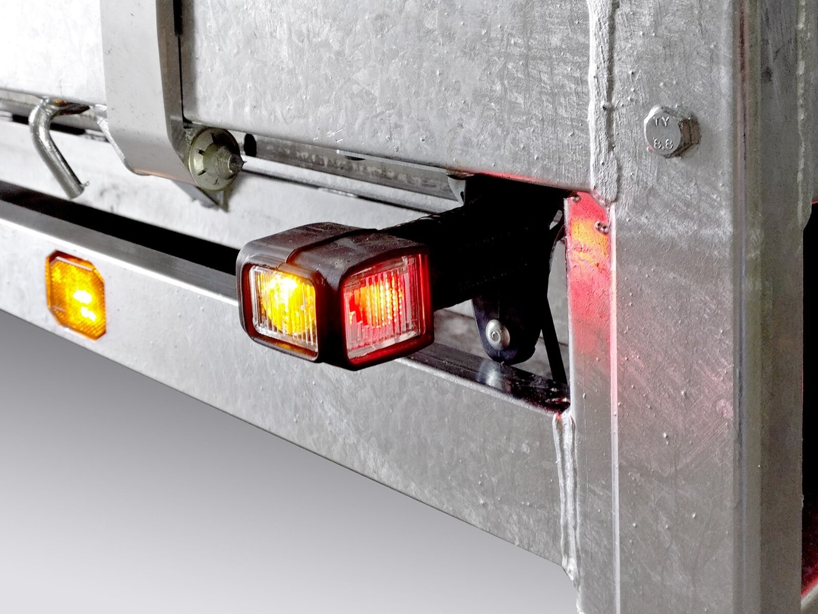 Achterzijde van een aanhangwagen met reflectoren en remlichten.