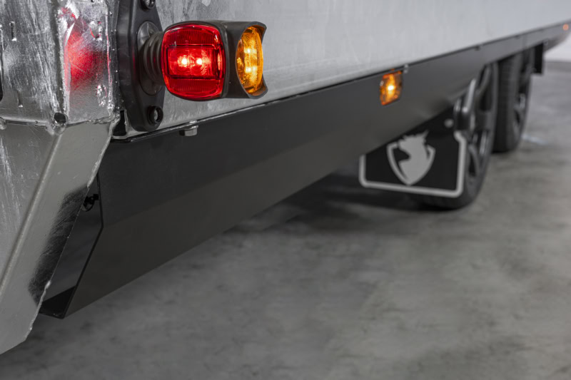 Achterzijde van een aanhangwagen met rode en oranje verlichting, reflectoren en stevige constructie.