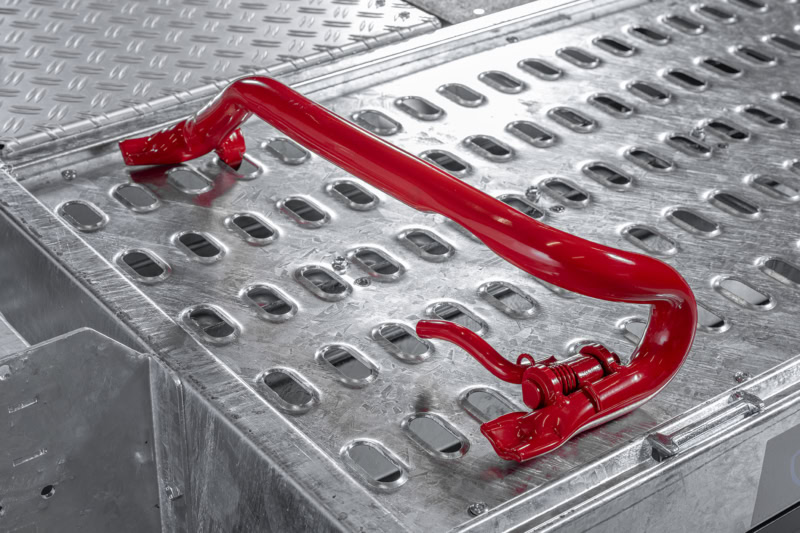 Veiligheidshandgreep voor aanhangwagen op metalen vloer.