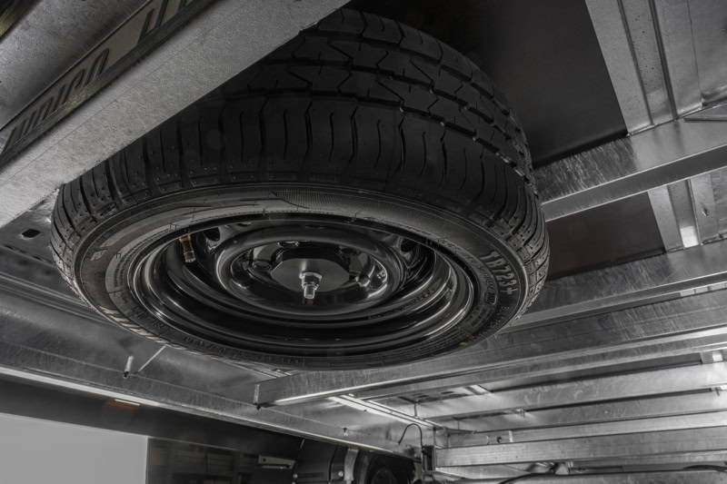 Aanhangwagen met reservewiel onder de trailer, geschikt voor transport.