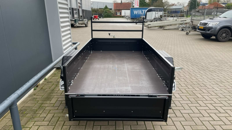 Zwarte open aanhangwagen met houten vloer voor transport.