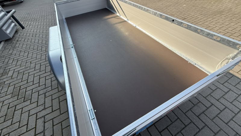 Aanhangwagen met open laadbak, geschikt voor transport.