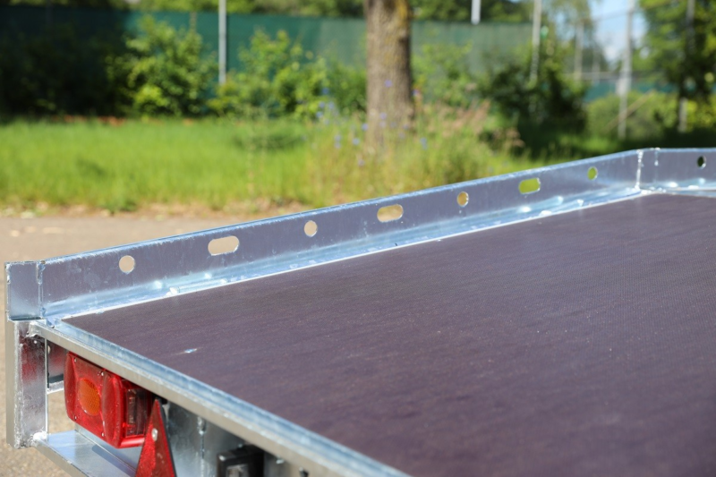 Transportaanhanger met houten vloer en metalen rand voor diverse ladingen.